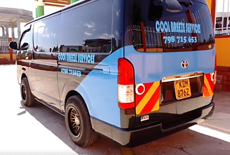 Blue and black Cool Breeze Services Toyota HiAce van, rear three-quarter view