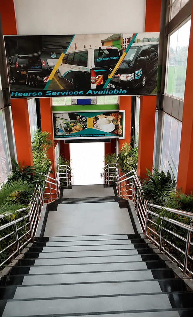 The covered entrance stairway at Cool Breeze Funeral Home, with planters, steel handrails and the Hearse Services Available banner overhead