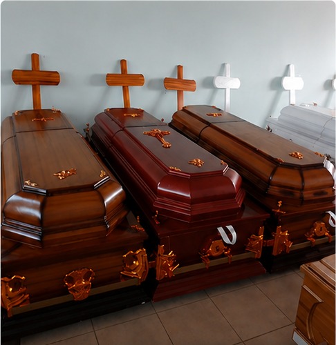 Brown, mahogany and light timber coffins with gold fittings, displayed beneath wooden crosses
